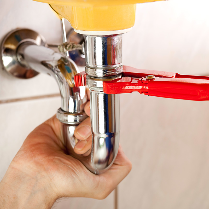 Plumber fixing a sink in bathroom